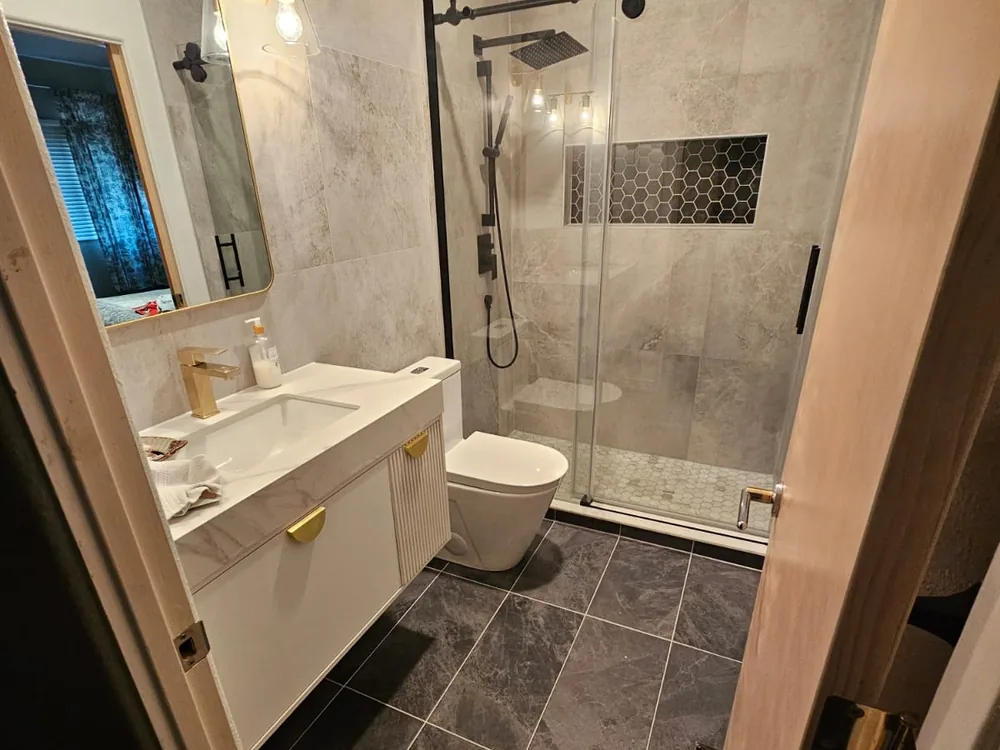 Completed bathroom with double vanity and tiled shower